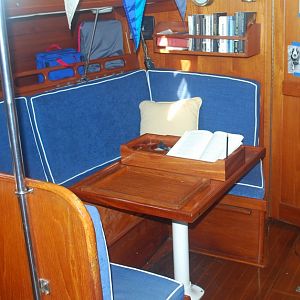 Ericson 381 cabin table, reduced in size 2" all around. Note movable mahogany caddy to secure drinks, coffee cup and book, and nonskid tray for easy t