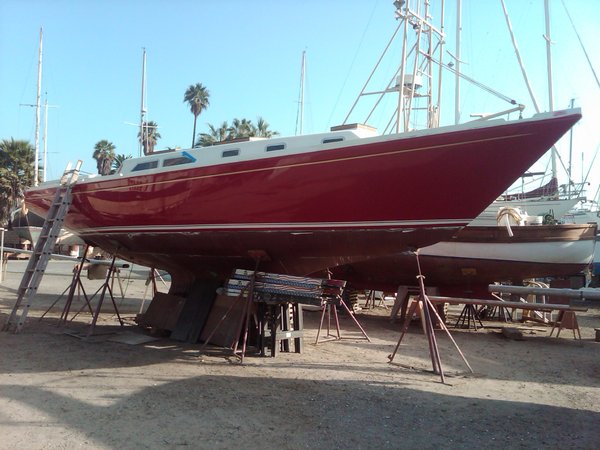 Painted her AwlGrip Vivid Red hull (five coats) with Insignia White double water line.  Cordovan Gold sheer stripe.